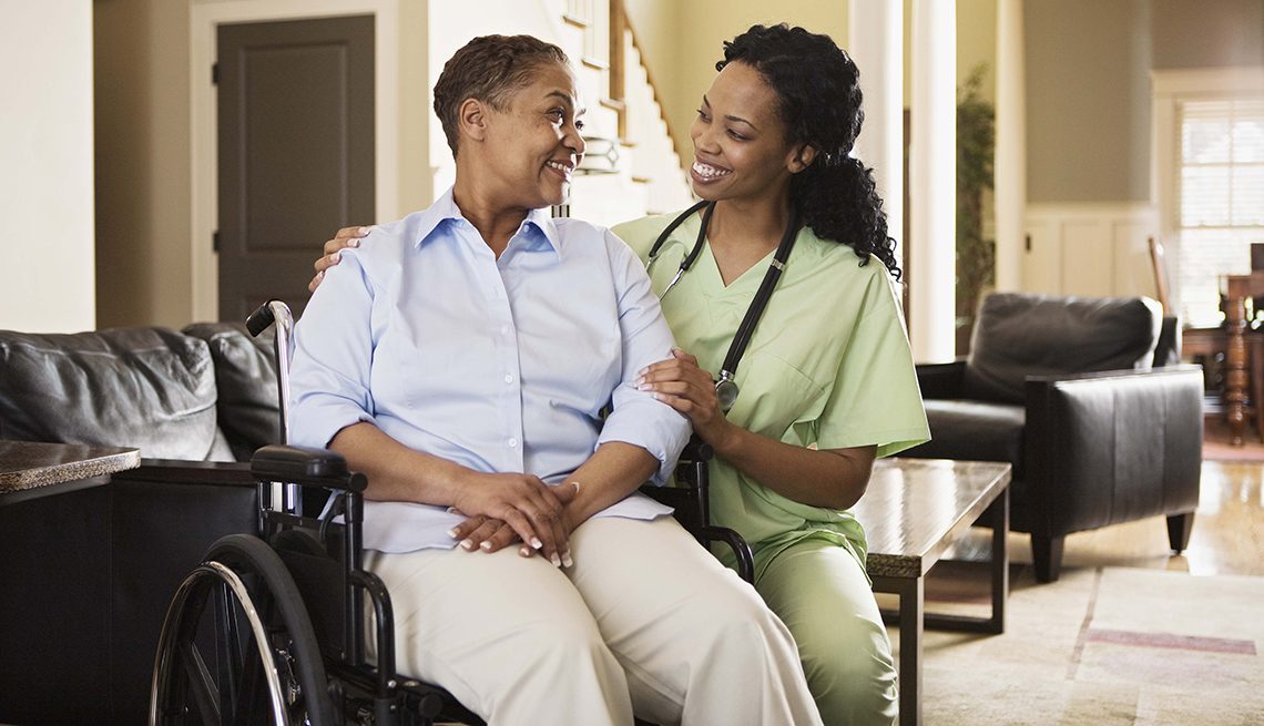 Nurse with woman in wheelchair at home